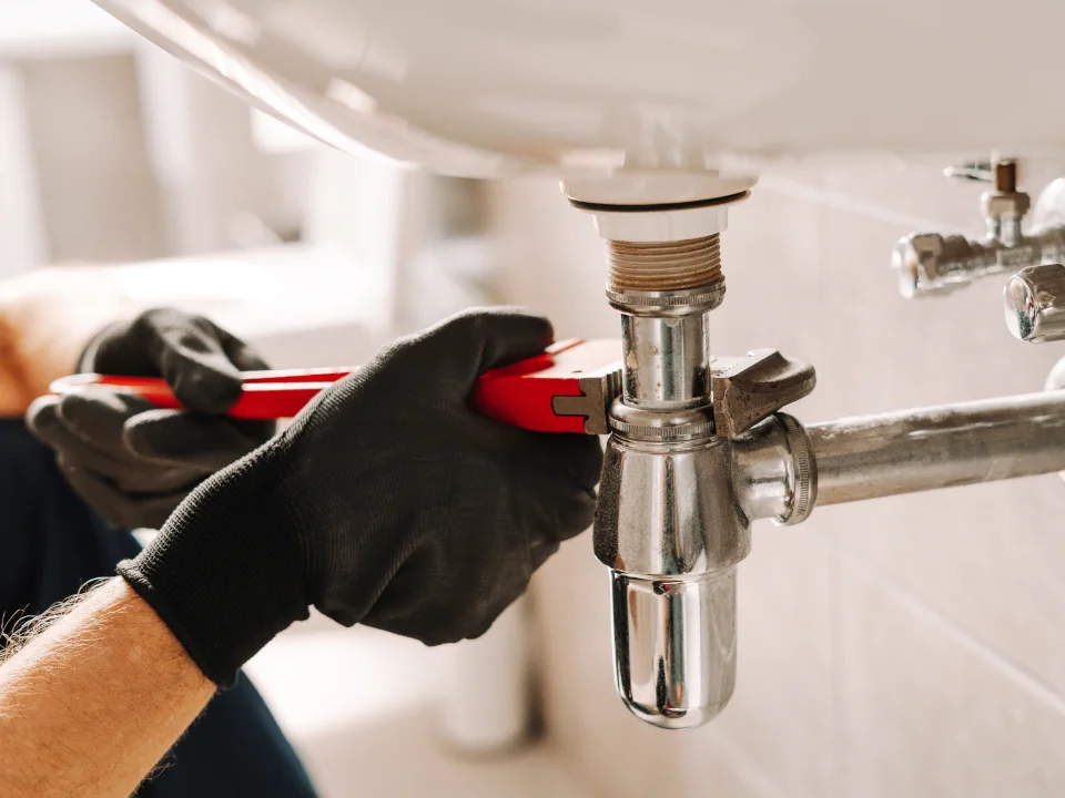 Plumber servicing a water pipe