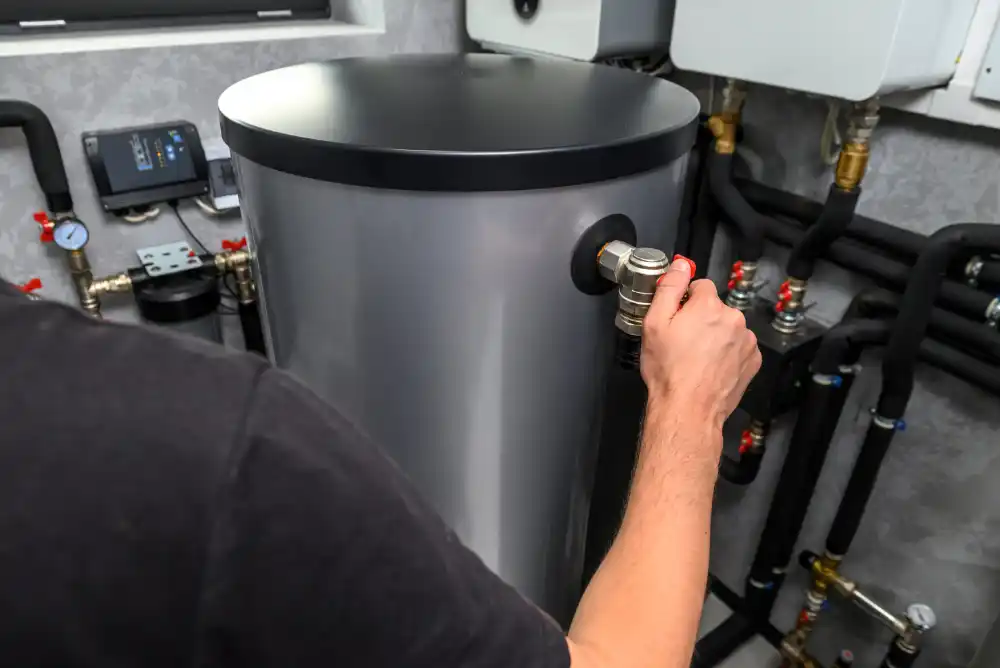 Plumber repairing a valve on a water heater tank.